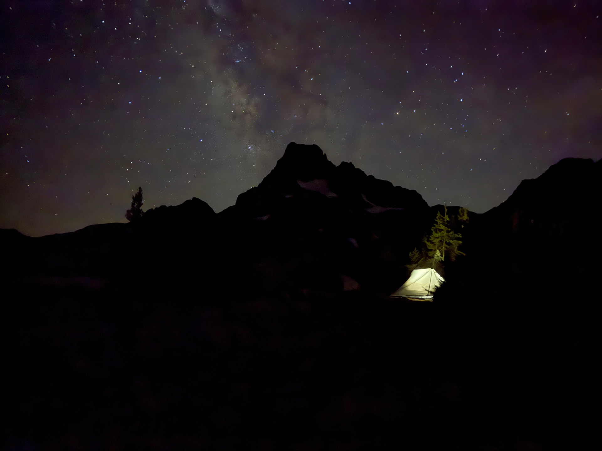 Milky Way rising above Banner Peak with a lit tent at Thousand Island Lake